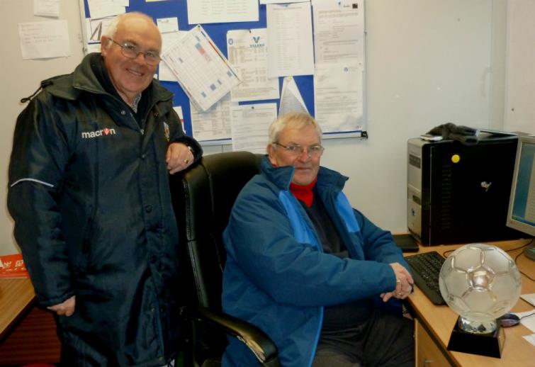 David Hughes and Barry Vaughan show the glass football off whilst at work in the club office.